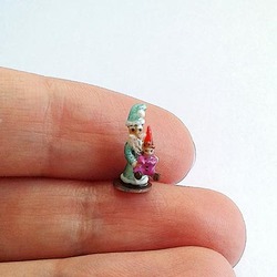 Tiny Santa holds the tiny baby gnome